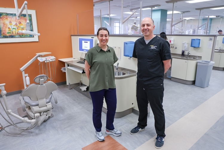 스크럽을 입고 함께 서 있는 두 명의 치과의사