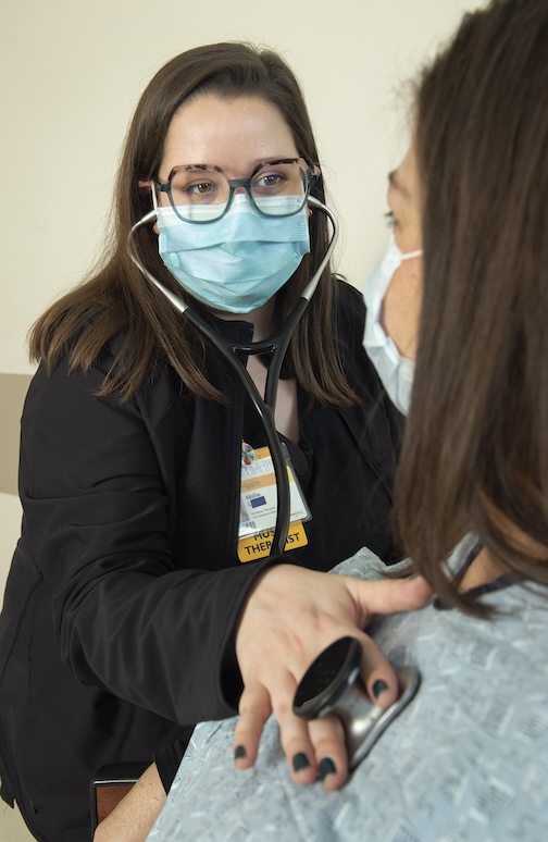 여자는 청진기를 통해 다른 여자의 심장 박동을 듣습니다.