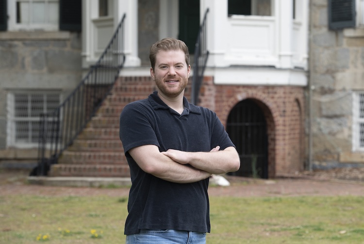 팔짱을 끼고 건물 앞에 서있는 남자