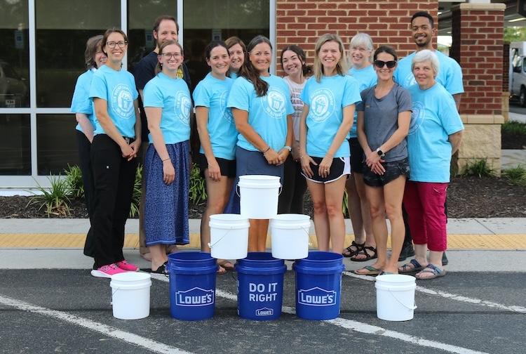 파란색 셔츠를 입고 함께 서 있는 사람들의 그룹