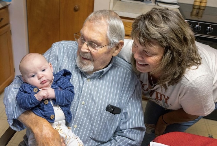 아기를 안고 있는 나이든 남자와 웃는 얼굴을 바라보는 나이든 여자
