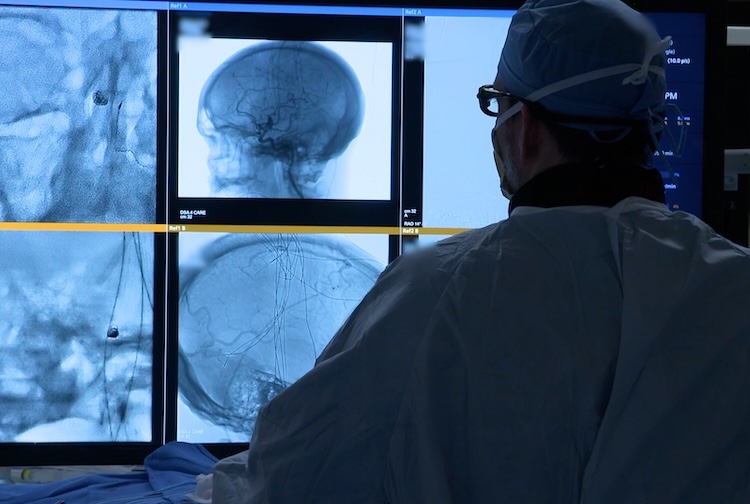 정맥을 탐색하면서 환자의 실시간 이미지를 보고 있는 외과의사