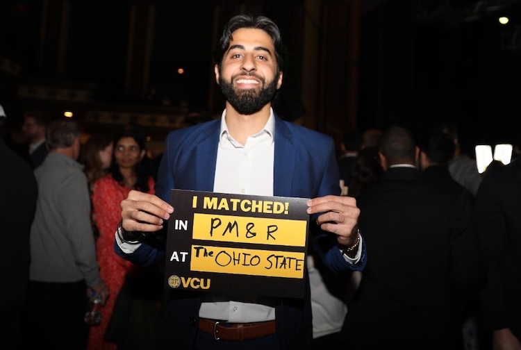 양복을 입고 표지판을 들고 웃고 있는 남자