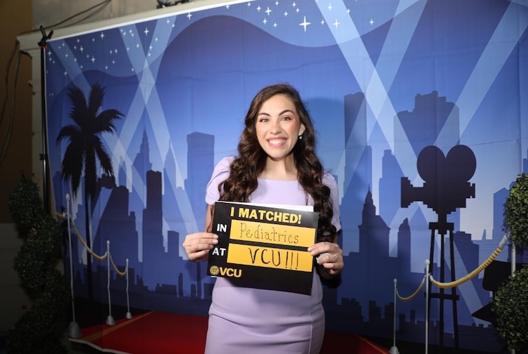 여자가 웃고 있는 표지판을 들고 있습니다