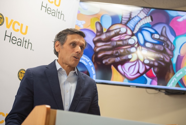 마이클 라오 대통령은 군중들에게 연설하는 동안 파란색 정장 재킷을 입습니다