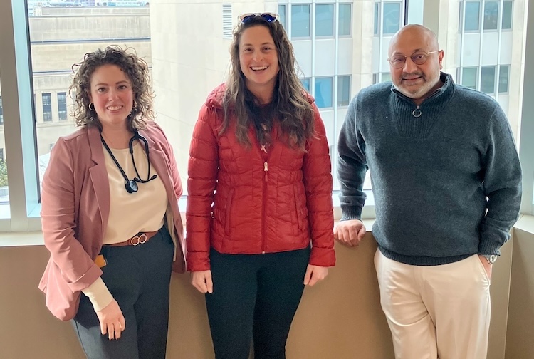 창가에 함께 서서 웃고 있는 세 사람