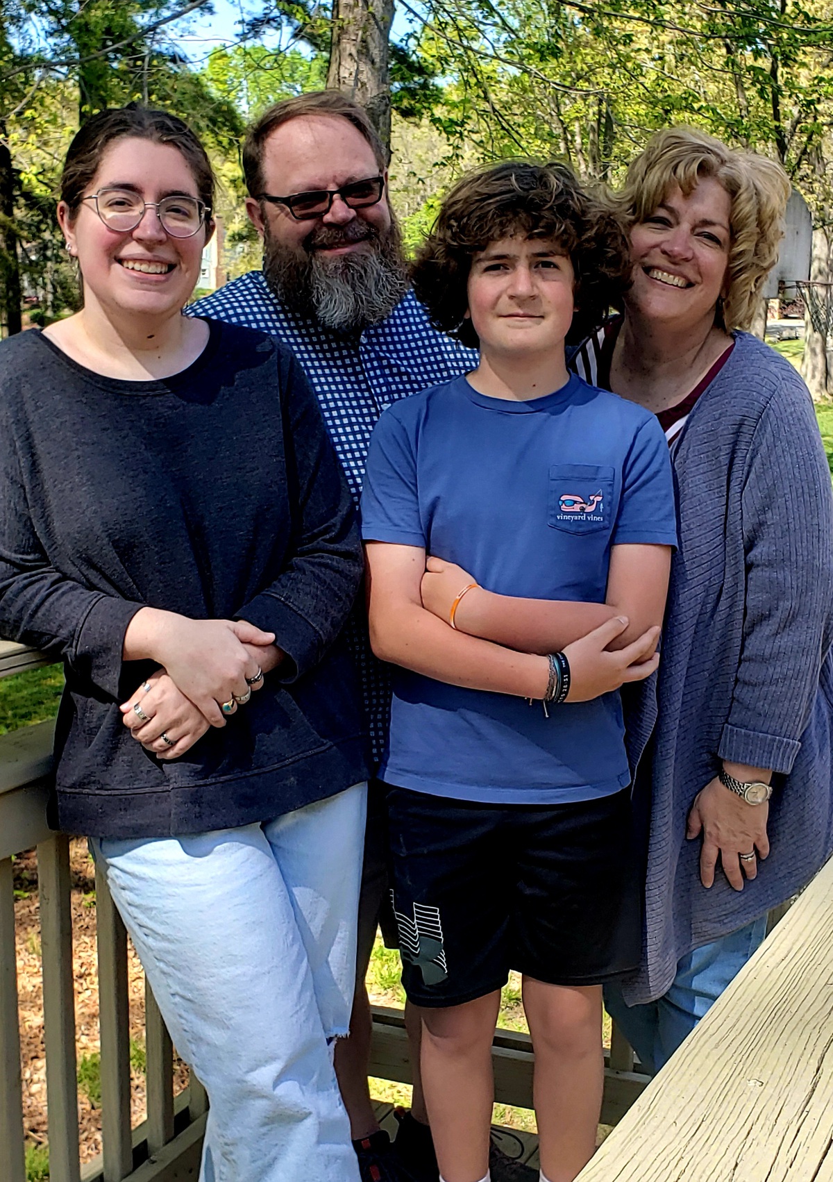 4인 가족이 숲이 우거진 지역에 함께 서 있습니다.