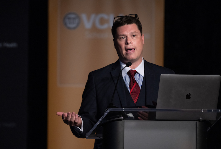 Albert Arias, M.D.가 카지노사이트의 Stravitz-Sanyal 간 질환 및 대사 건강 연구소의 첫 학술 심포지엄에서 연단에서 자신의 연구 결과를 발표하고 있습니다.