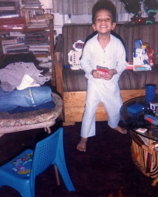 집에 서서 웃고 있는 어린 소년