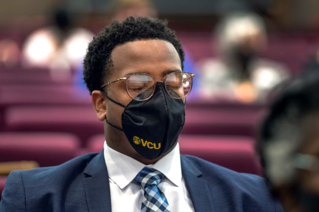 의대생 Miles McConner가 묵념의 시간 동안 기도하고 있습니다.