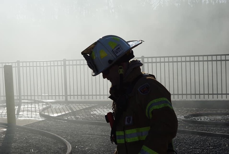 그렉 라이츠는 화재 진압 후 연기가 자욱한 연기 속에 서 있습니다.