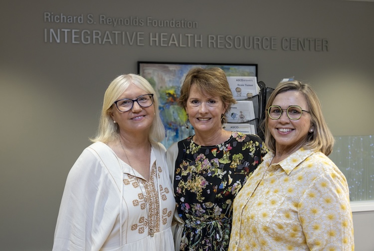 함께 서서 웃고 있는 세 명의 여성