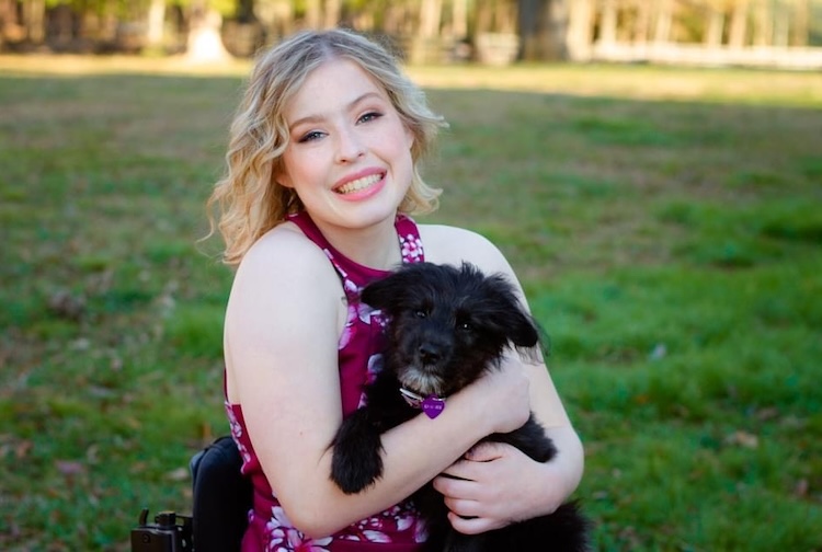 강아지와 함께 휠체어에 앉아 있는 젊은 여성