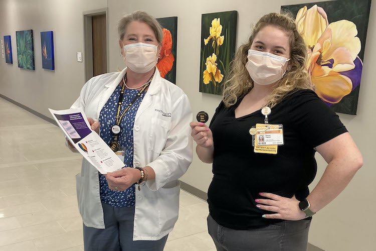 대명사 핀을 들고 포즈를 취하는 여성 의사와 여성 환자 액세스 담당자