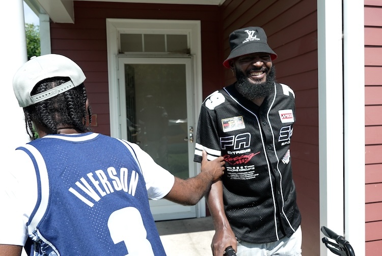 친구와 함께 현관에 보행자와 함께 서있는 남자