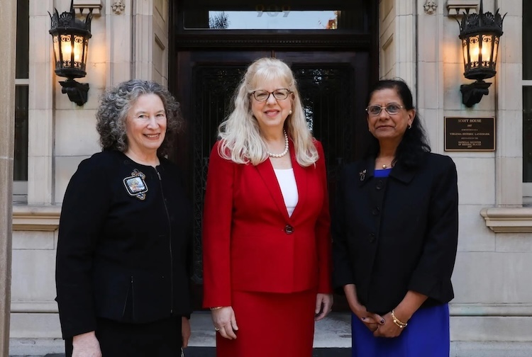 건물 밖에 함께 서 있는 세 명의 여성