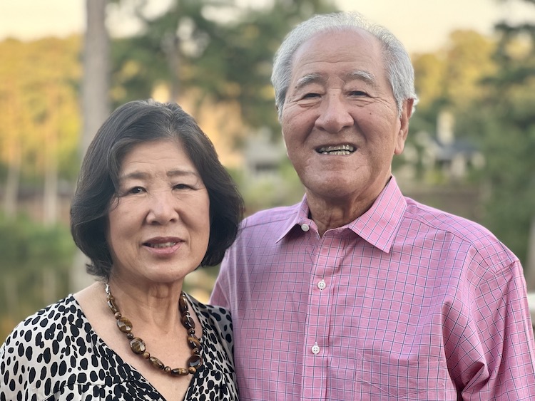 두 노인이 미소를 지으며 나란히 서 있습니다.