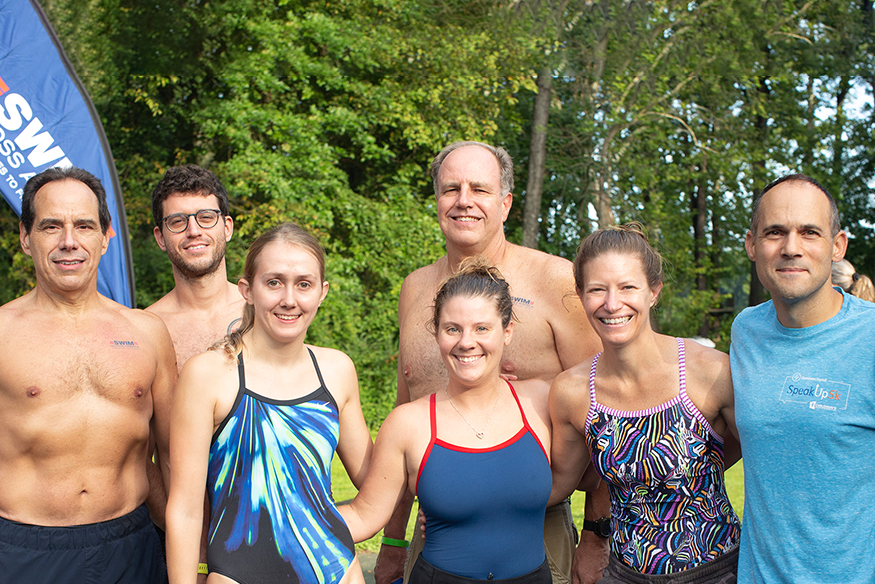 그룹은 수영복을 입고 함께 서 있습니다.