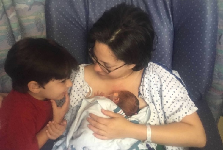 작은 아기와 어린 소년이 그들과 이야기하는 병원 침대에있는 어머니