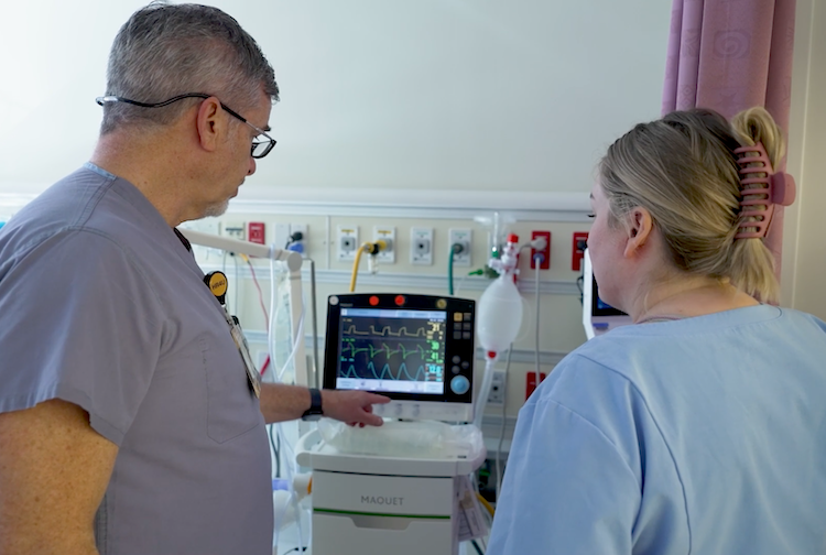 두 명의 카지노 종사자가 환자의 심장 박동을 추적하는 모니터를 보고 있습니다