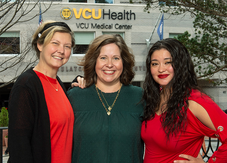 세 명의 여성이 함께 서서 웃고 있습니다. 카지노사이트 건물 밖에 있습니다