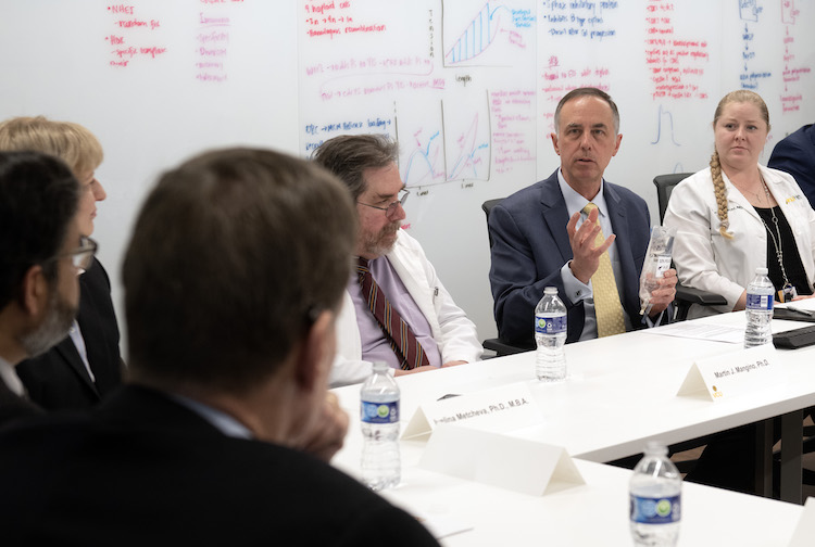 여러 사람이 건강 과학 및 생명 공학에 관한 원탁 토론에 참여합니다.