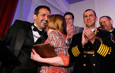 빛나는 기사 갈라 행사에서 박수를 치며 포옹하는 사람들.