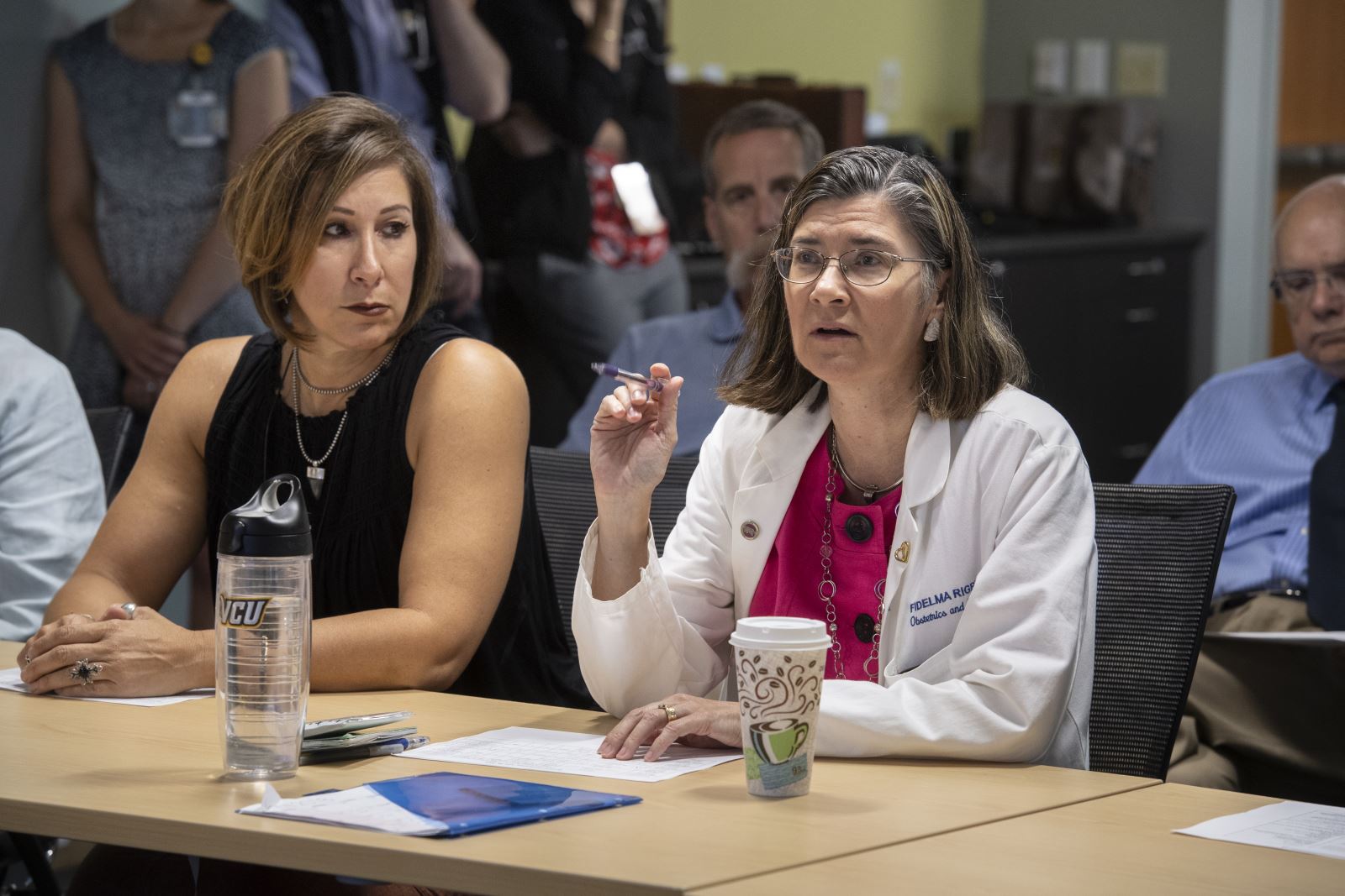 카지노 서비스 제공자들이 테이블에 앉아 복잡한 산전 관리에 대해 논의합니다.